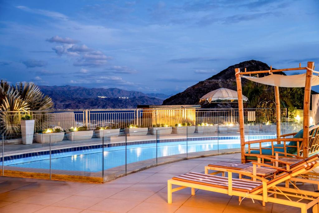 a swimming pool with two chairs and an umbrella at הבית על ההר - Ella Sun in Eilat