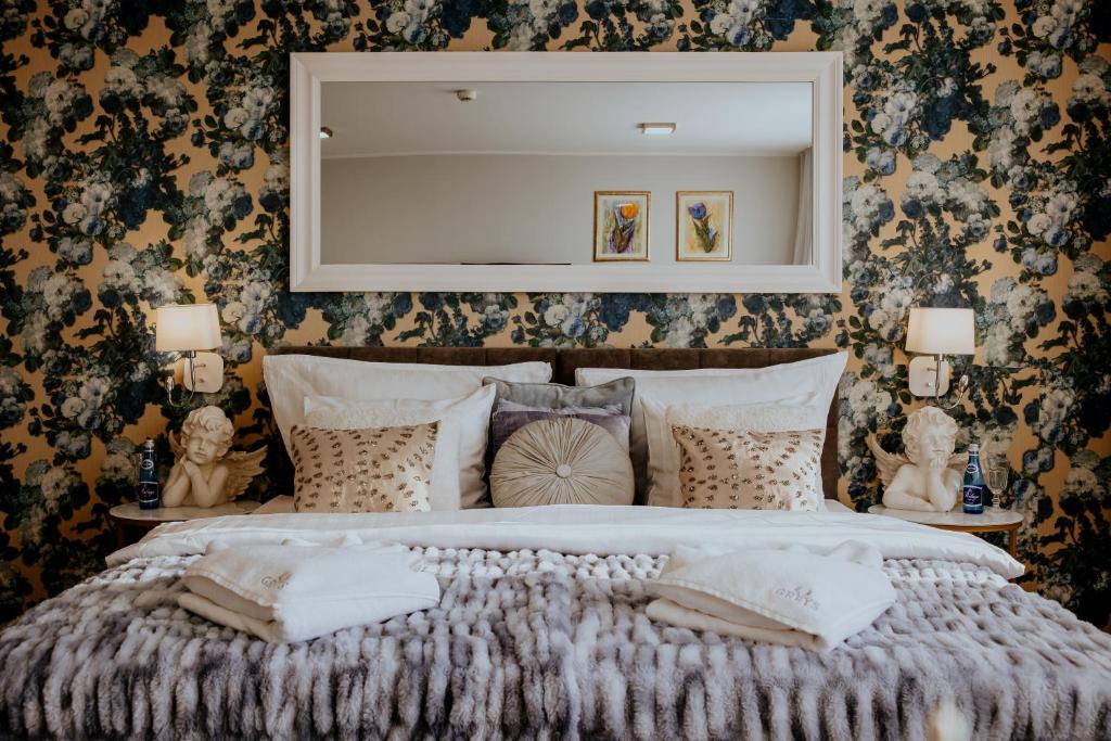 a bedroom with a large bed with a mirror on the wall at Hotel Greys Polonia in Zasutowo