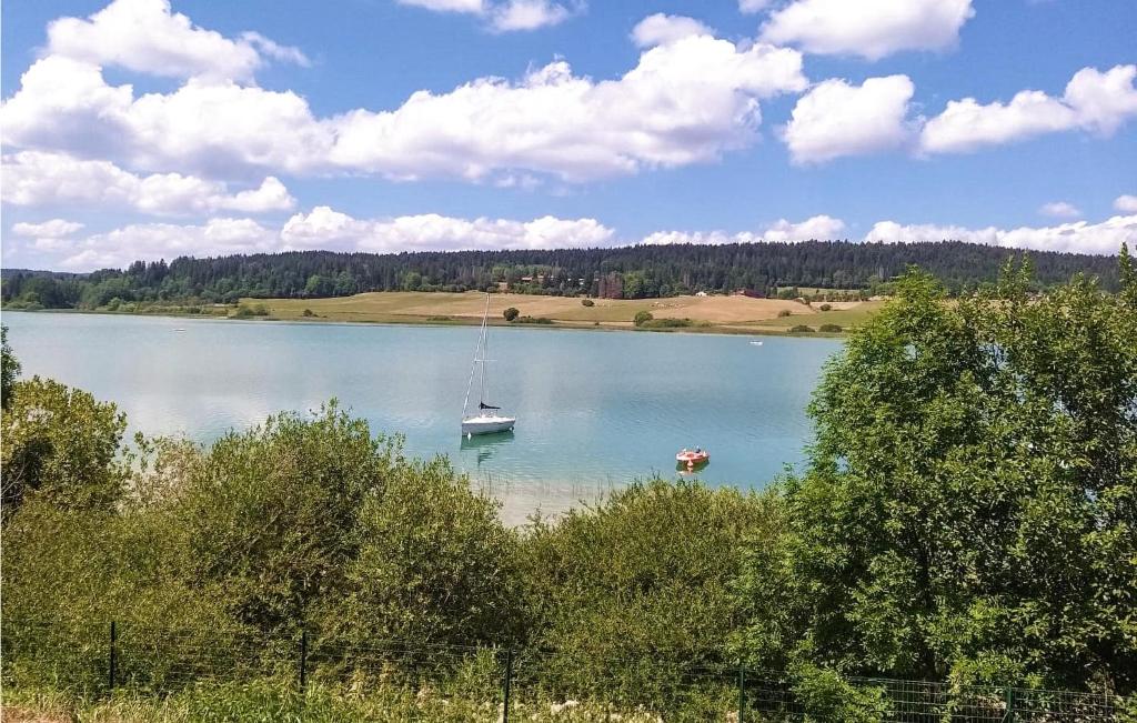 a lake with a boat in the middle of it at Nice Home In Les Premiers-sapins With Ethernet Internet in Athose