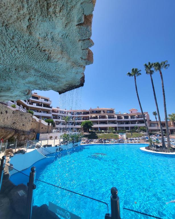 a large swimming pool in a resort with palm trees at Golf del Sur Albatros Park Piscina Climatizada fast wifi in San Miguel de Abona