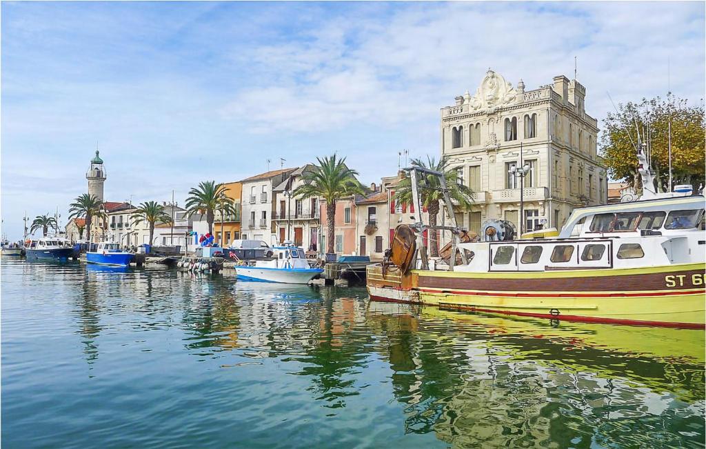 エーグ・モルトにある2 Bedroom Amazing Home In Aigues-Mortesの船が建物のある運河に停泊している