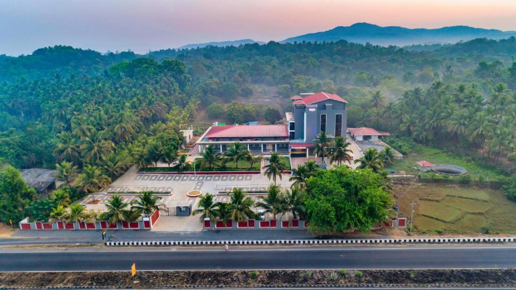 une vue aérienne d'un bâtiment au milieu d'une montagne dans l'établissement Hotel Aaradhya Adorer, à Kudāl