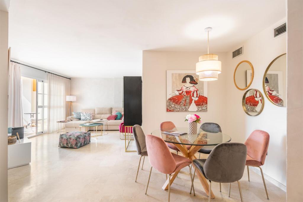 een woonkamer met een tafel en stoelen bij Apartamento de diseño 2 terrazas en Estepona by Rent Me in Estepona