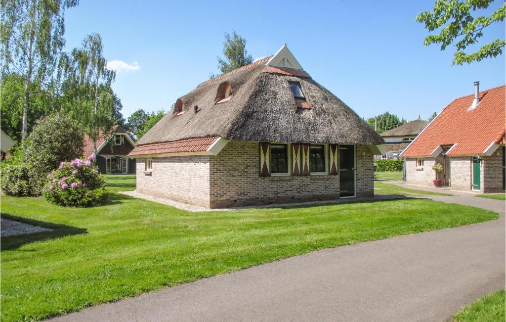 ein kleines Backsteinhaus mit einem Strohdach in der Unterkunft Gorgeous Home In Ijhorst With Wifi in IJhorst