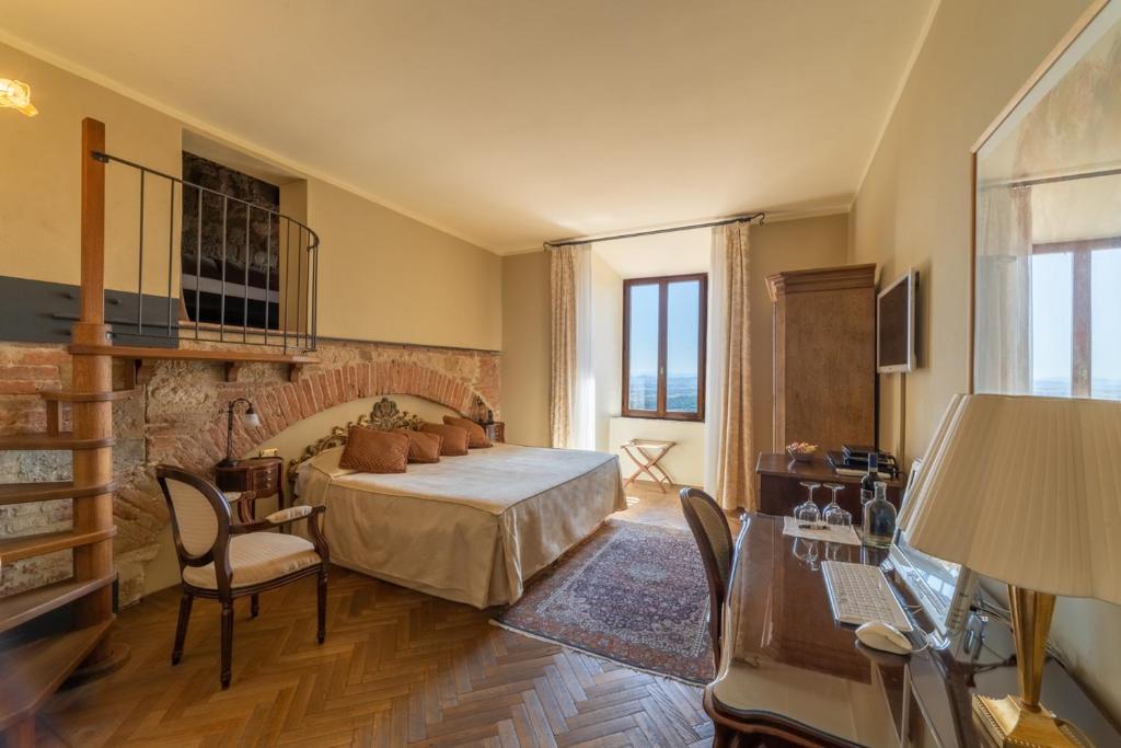 una camera con letto, tavolo e scrivania di La Locanda Di San Francesco a Montepulciano