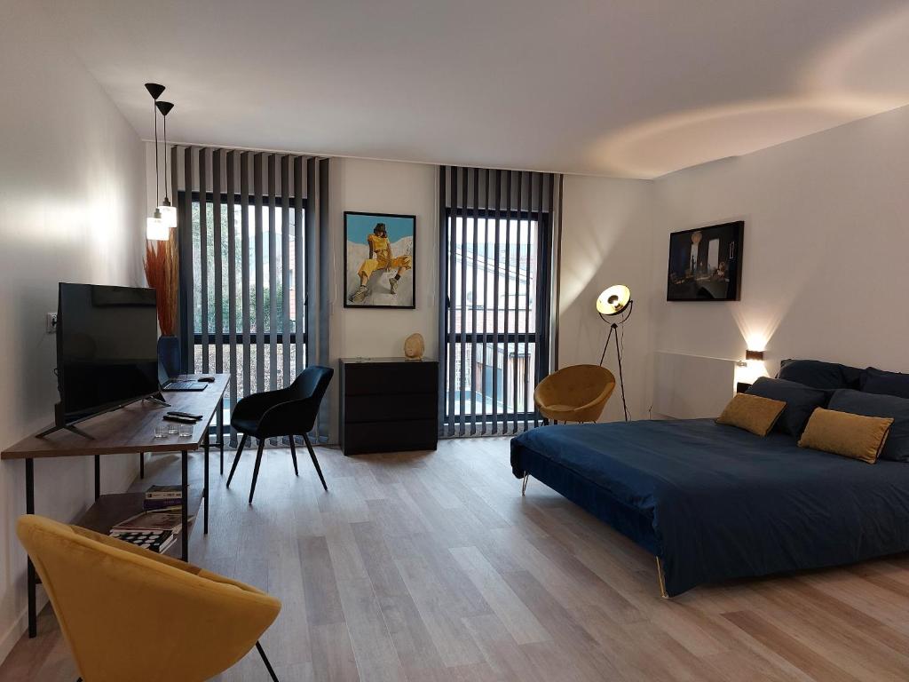 Urbs Amiens Sud في أميان: غرفة نوم مع سرير وغرفة معيشة مع مكتب