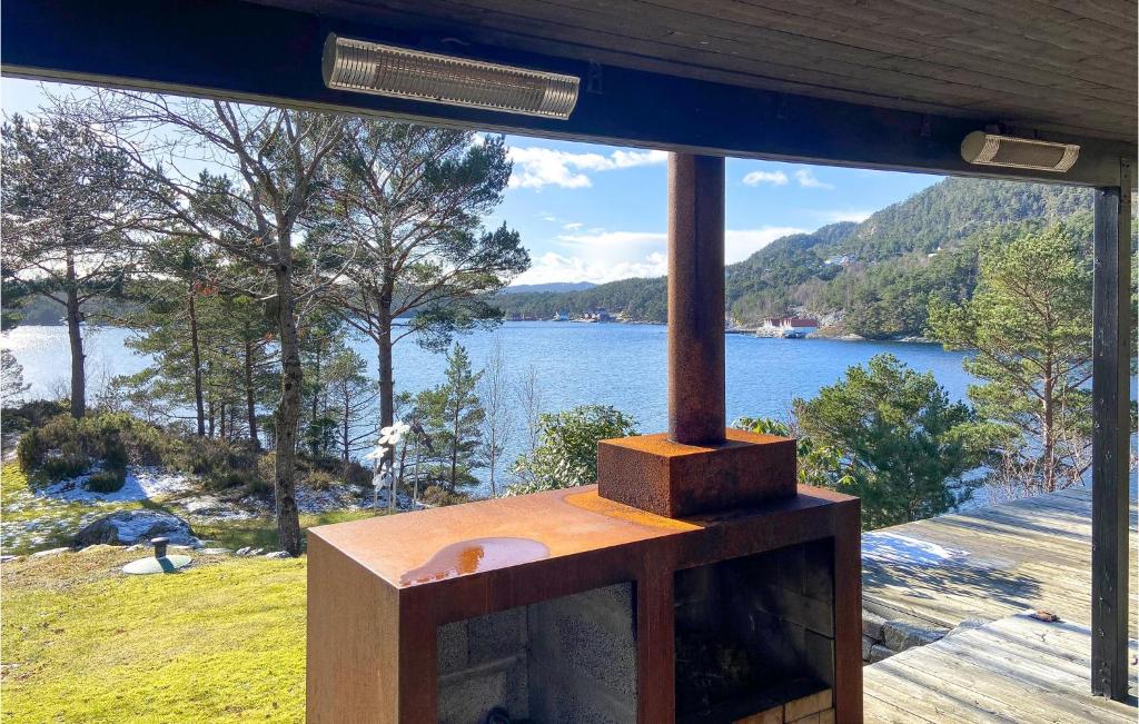 a wood stove with a view of a lake at Stunning Home In Mosterhamn With Kitchen in Mosterhamn