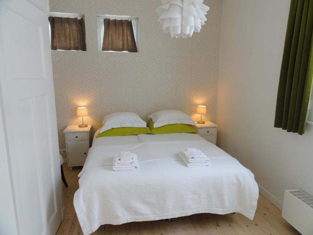 a bedroom with a white bed with two towels on it at Bickersbed in Amsterdam