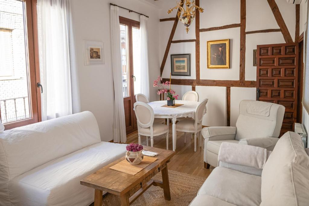uma sala de estar com mobiliário branco e uma mesa em Hammam de Zeid em Toledo