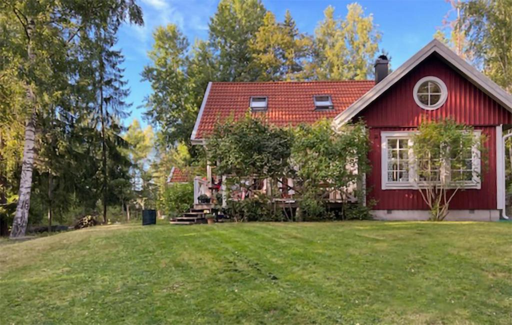 een rood huis met een rood dak en een tuin bij Lovely Home In Ljuster With Kitchen in Norra Ljustero