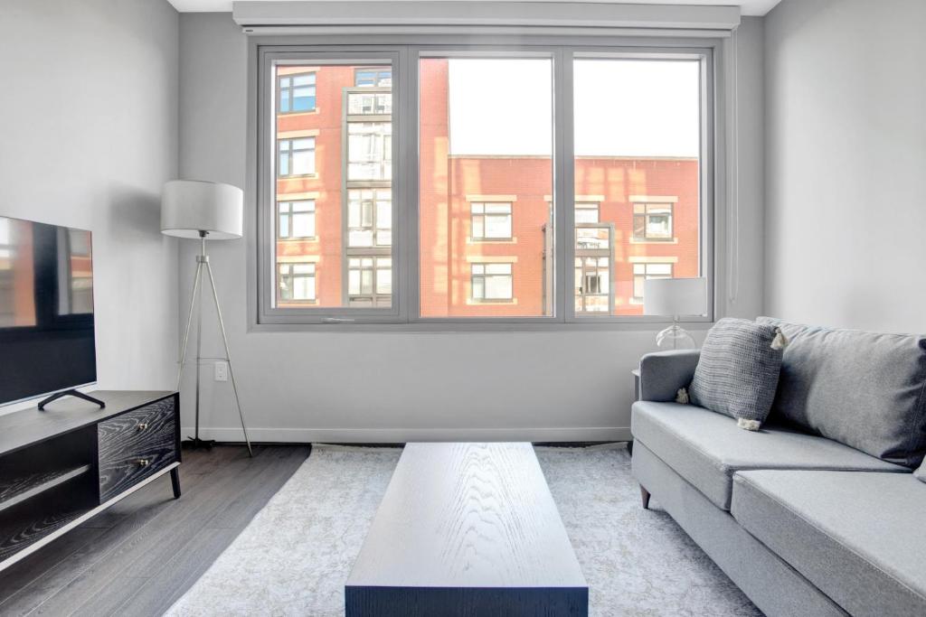 a living room with a couch and a large window at Clarendon 1BR w Gym WD Pool nr Metro WDC-381 in Arlington