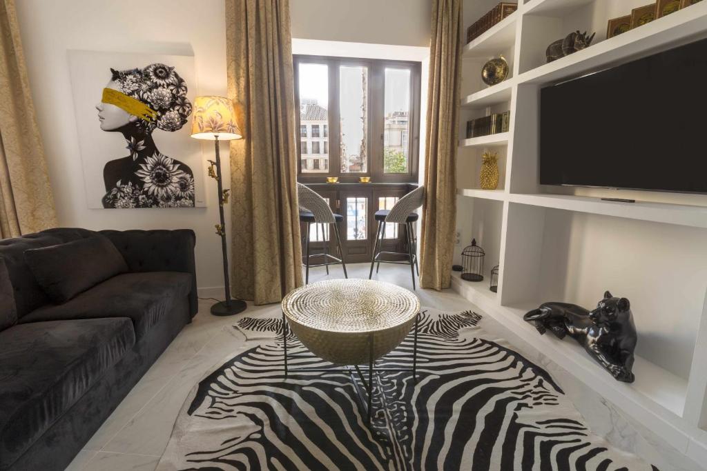 un soggiorno con tappeto zebrato e TV di THE CLOCK HOUSE Luxury Urban Suites a Málaga