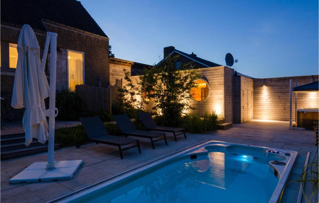 威斯圖特的住宿－Cozy Home In Westouter With House A Panoramic View，后院设有游泳池、椅子和房屋