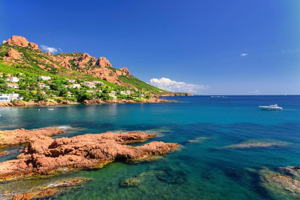 Vista sull'oceano con una barca in acqua di Super-cute colourful, cozy flat a Saint-Raphaël