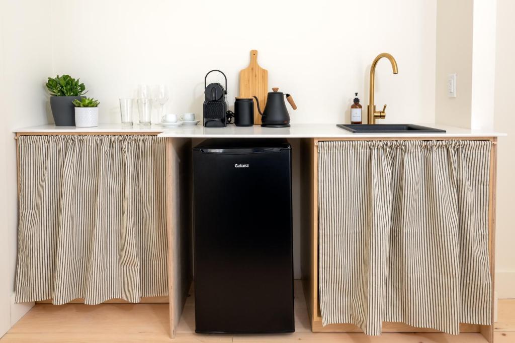 a kitchen with a black refrigerator under a counter at The August House in Windsor