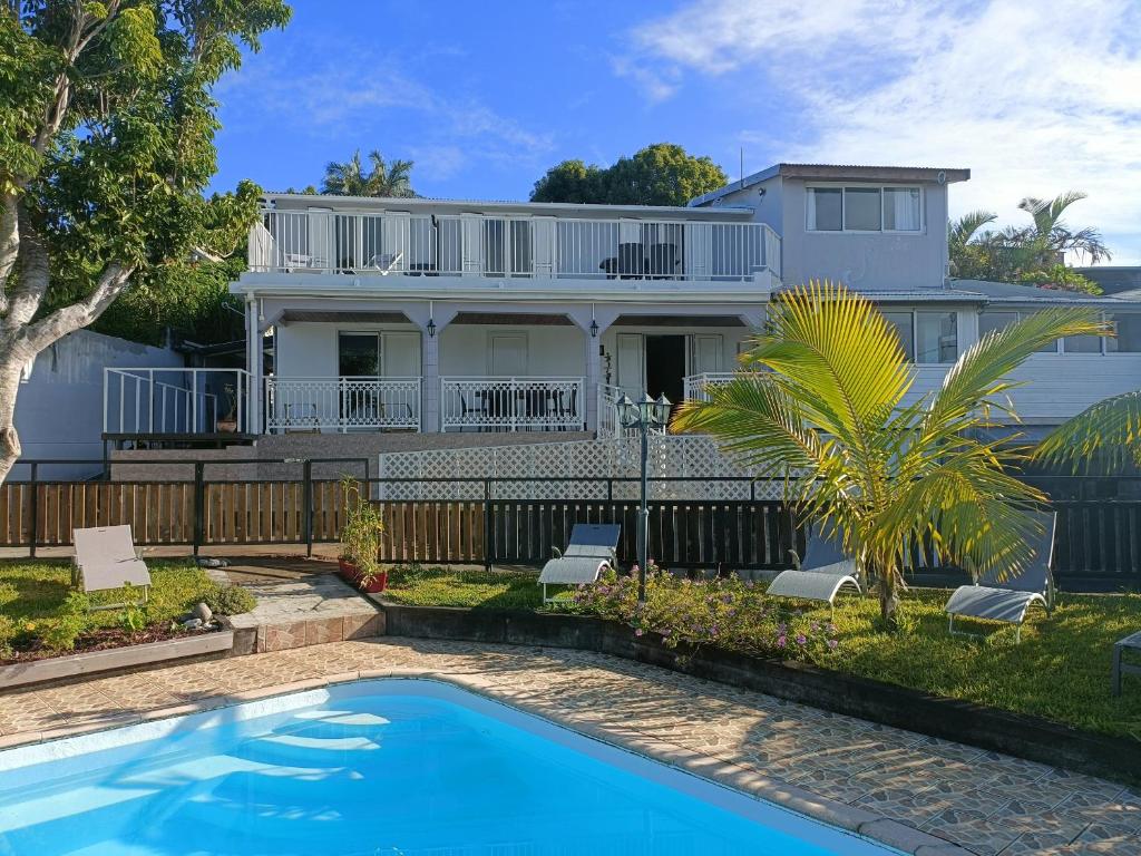 uma casa com piscina em frente a uma casa em Villa Couleurs du Sud Sauvage em Saint-Joseph