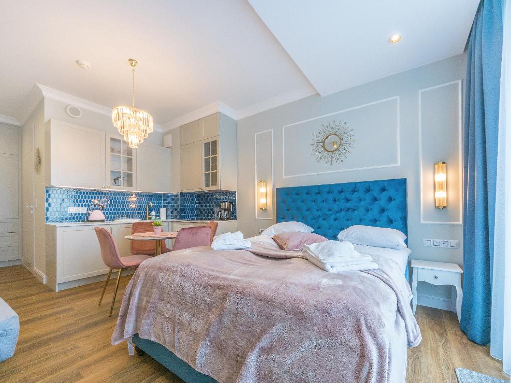 une chambre avec un grand lit et une tête de lit bleue dans l'établissement Flatbook - City Center Apartments Granaria II, à Gdańsk
