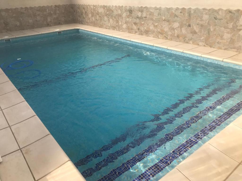 a swimming pool with blue water in a room at Casa Rural Villa María in Navahermosa