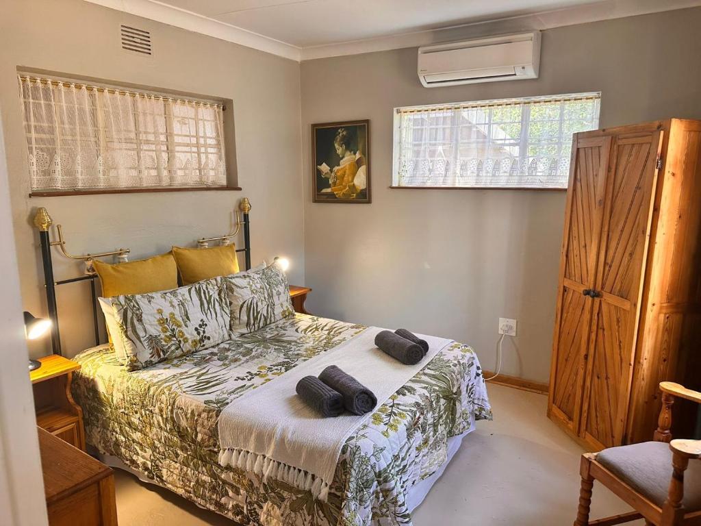 a bedroom with a bed with two towels on it at Farm stay at Rosemary Cottage on Haldon Estate in Bloemfontein