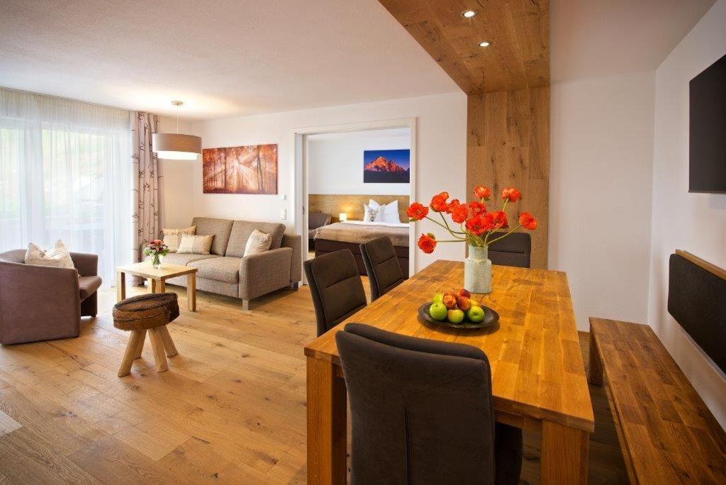 een woonkamer met een eettafel en een woonkamer bij 5 Sterne FeWo Allgäuer Alm mit Schwimmbad und Sauna in Oberstaufen
