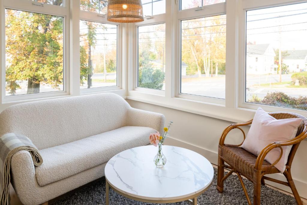 a living room with a couch and a table and windows at The August House in Windsor