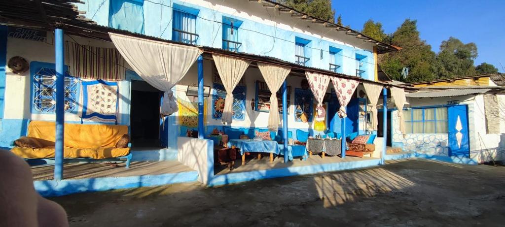 ein blau-weißes Gebäude mit Tischen und Stühlen in der Unterkunft Nefzi Guest House in Nefzi