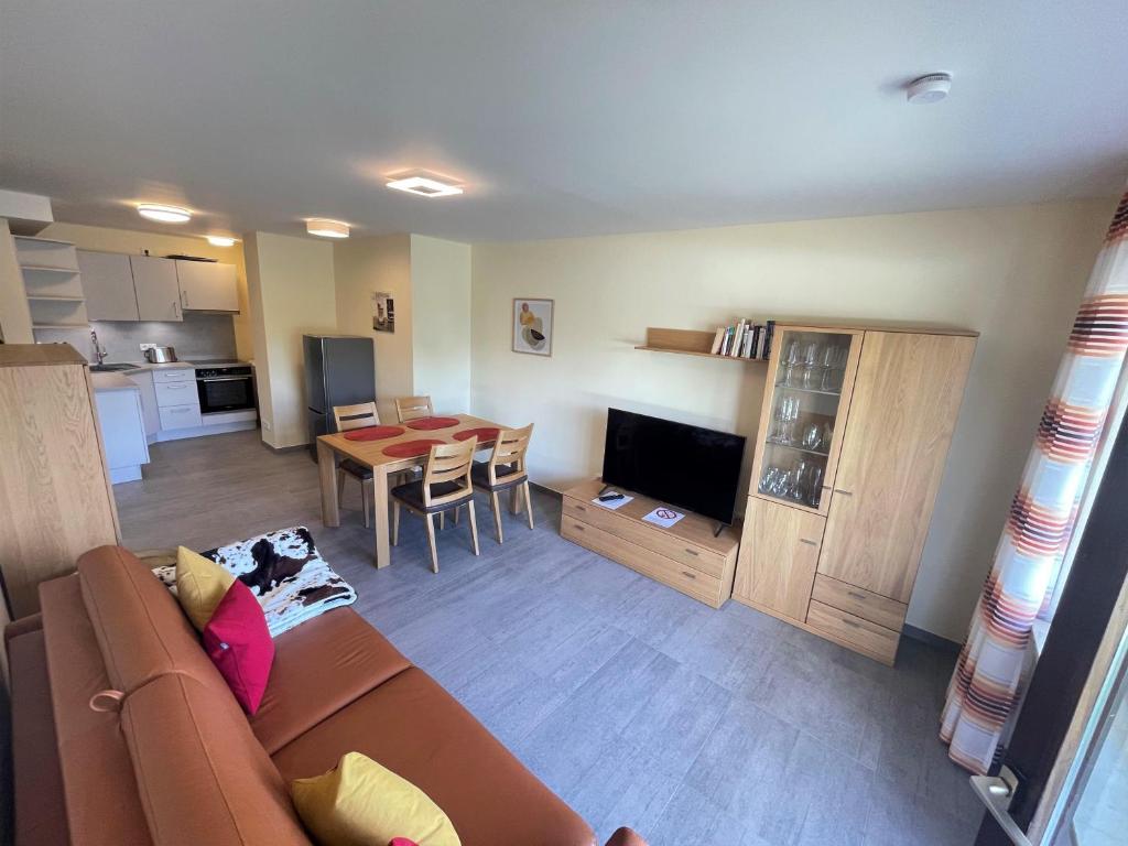 een woonkamer met een bank en een eetkamer bij Ferienwohnung Antonia am Staufenpark in Oberstaufen