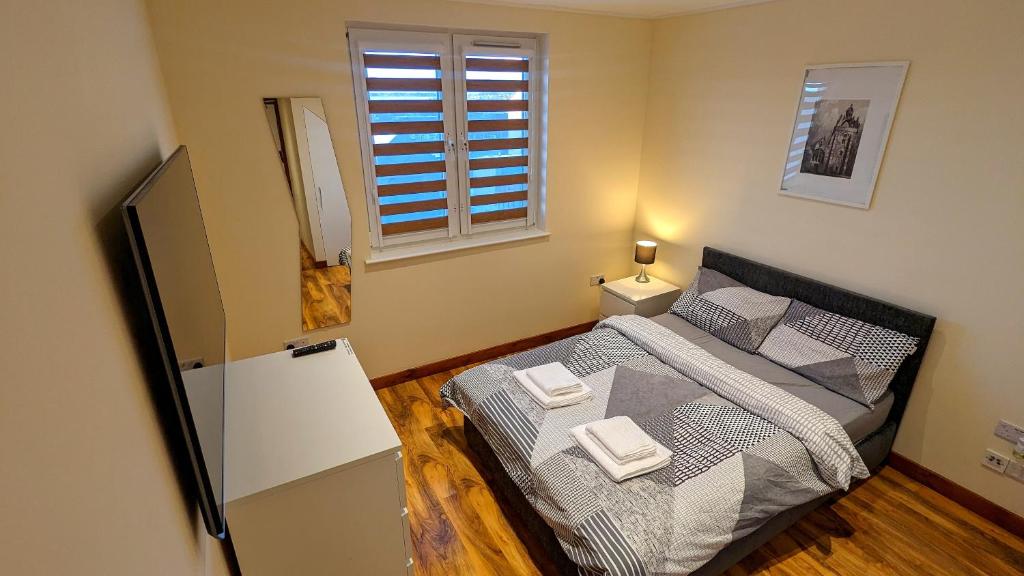 a small bedroom with a bed and a window at Private Room in Modern Apartment in Aberdeen