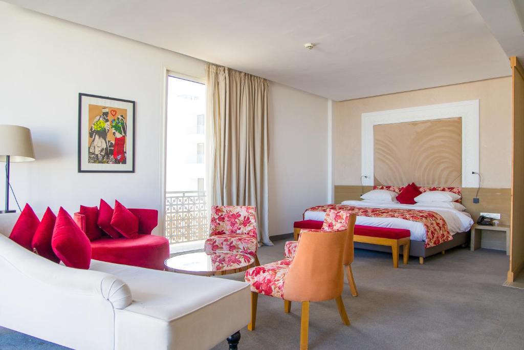 une chambre d'hôtel avec un lit, un canapé et des chaises dans l'établissement Mandarin Palace Hotel & Spa, à Tanger