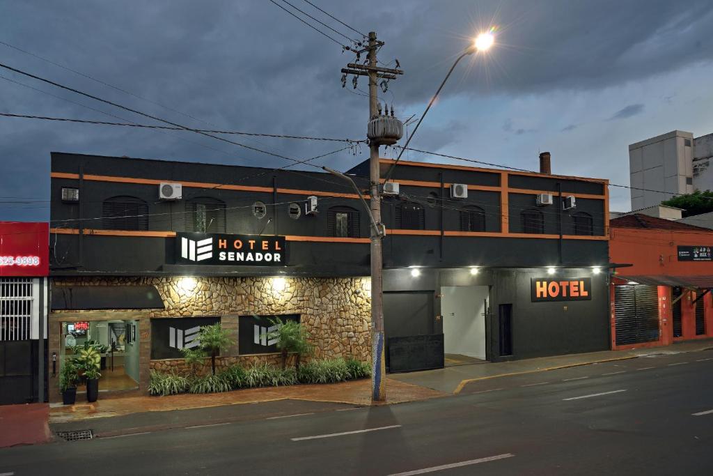 un edificio de hotel en una esquina por la noche en HOTEL SENADoR, en Ribeirão Preto