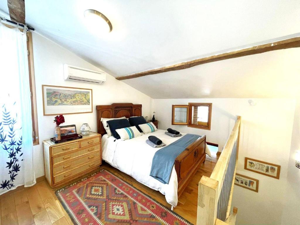 um quarto com uma cama e uma cómoda em madeira em La Grange aux hirondelles em Laroque-des-Albères