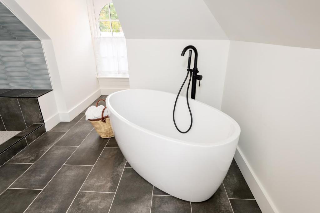 a white bath tub in a bathroom with a tile floor at The August House in Windsor