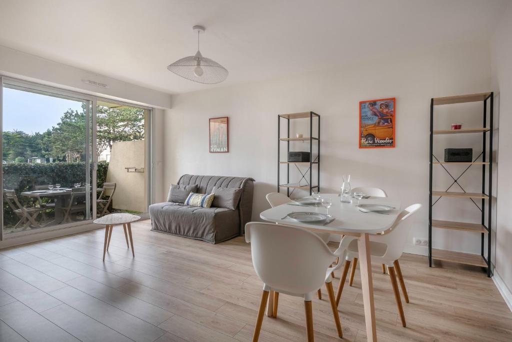 a living room with a table and a couch at Coquet appartement a 300 m du port du Pouliguen in Le Pouliguen