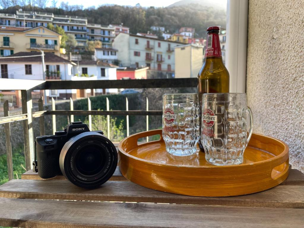 uma câmara e uma garrafa de cerveja e copos numa mesa em La casa di Nettuno em La Spezia