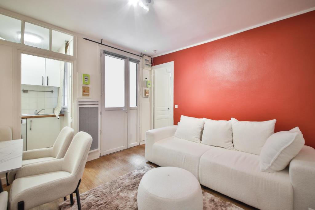 - un salon avec un canapé blanc et un mur rouge dans l'établissement 0#Appart 2pers#Jardin Luxembourg#NECKER, à Paris