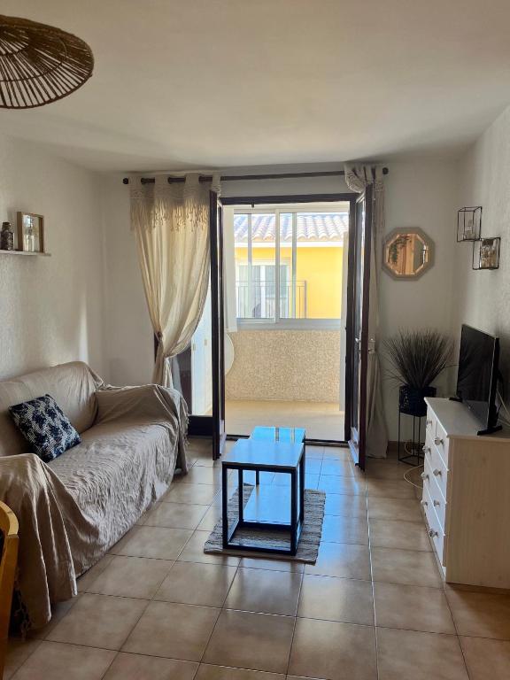 un salon avec un canapé et une table dans l'établissement AS23037 -P2 avec parking privé à 2 pas de la plage, au Grau-du-Roi