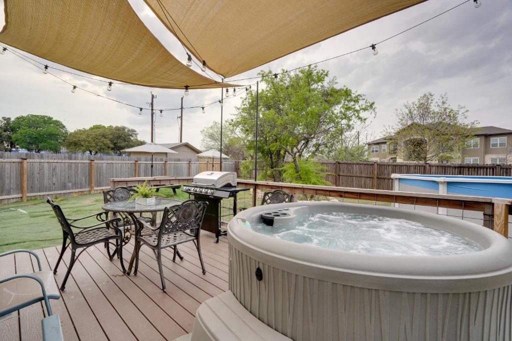a hot tub on a deck with a table and chairs at Home with Game Room and Hot Tub, 1 Mi to SeaWorld in San Antonio