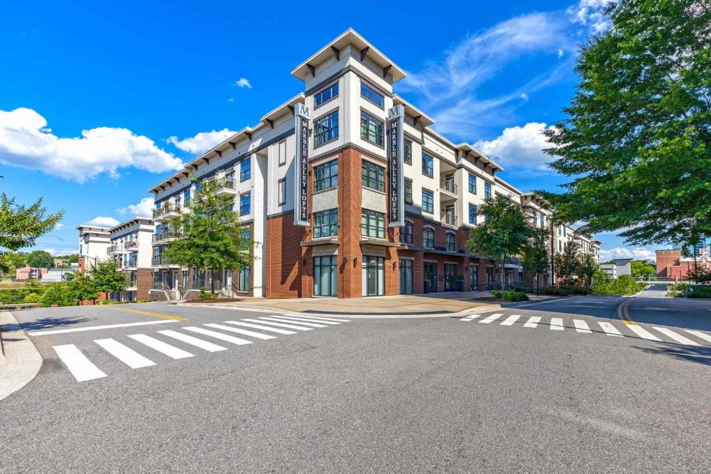 a large building on a street with a crosswalk at Cozy and Bright Apartments at Marble Alley Lofts in Downtown Knoxville in Knoxville