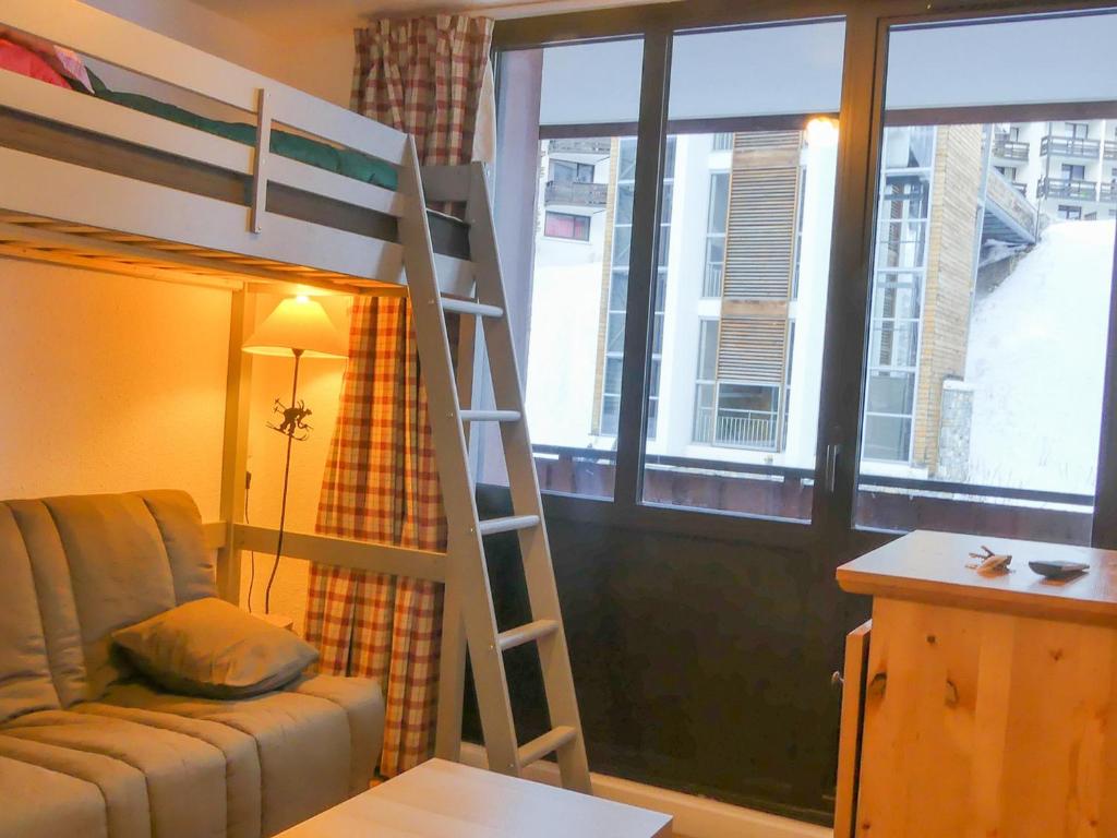 een kamer met een stapelbed, een bank en een raam bij Studio Tignes, 1 pièce, 3 personnes - FR-1-502-450 in Tignes
