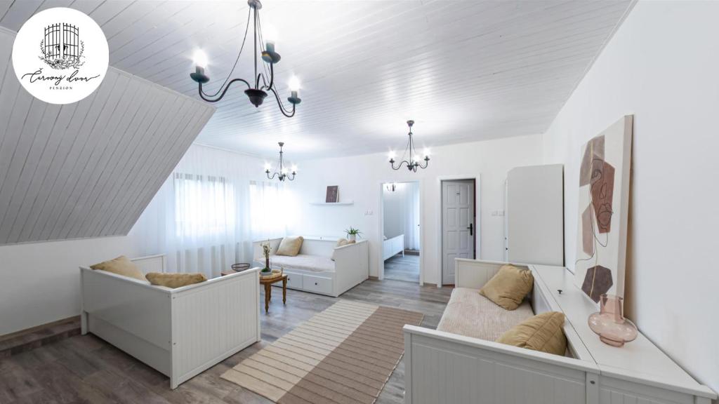 a white living room with a couch and a table at Penzión Čarovný dvor 