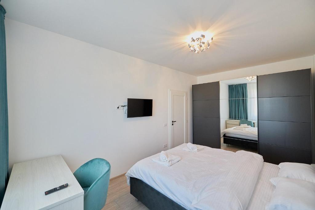 ein kleines Schlafzimmer mit einem Bett und einem TV in der Unterkunft Alessandro Home 7 Luxury Centru Palas Mall Iași Q Residence in Iaşi
