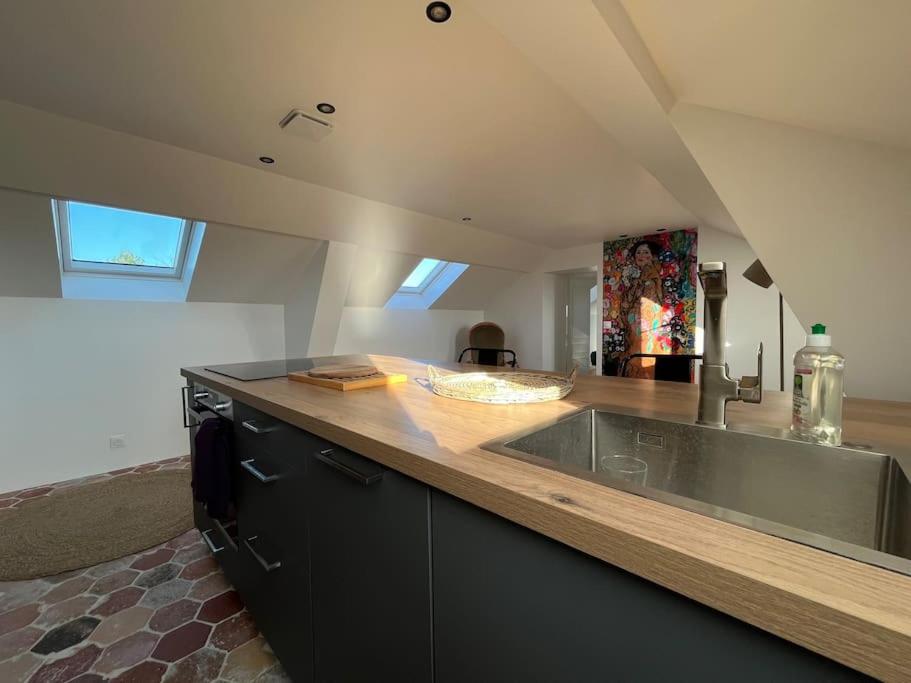 a kitchen with a sink and a wooden counter top at Sur les toits de Fontainebleau - Hypercentre in Fontainebleau