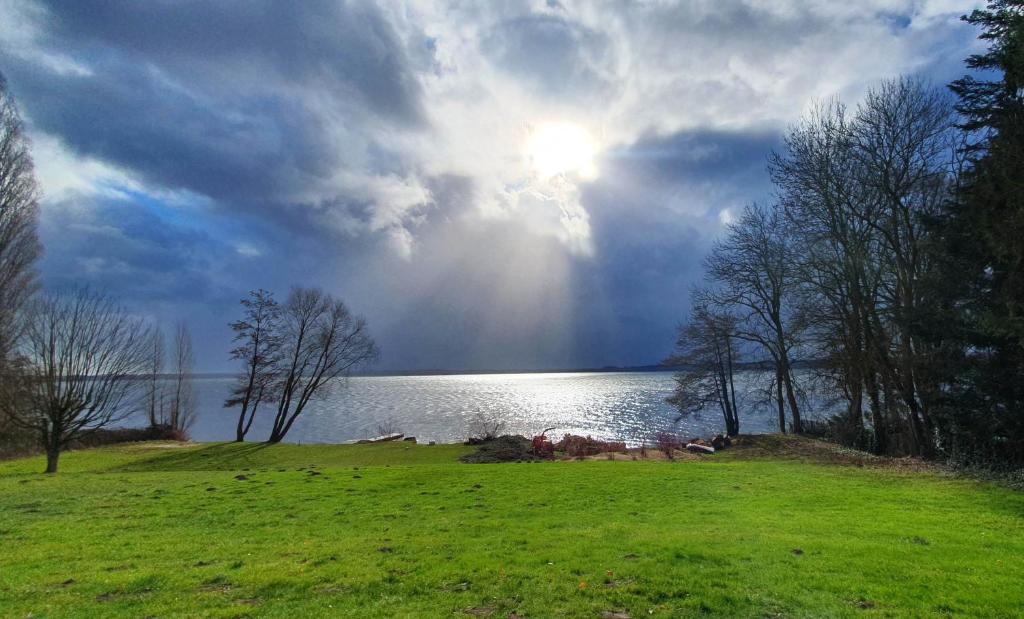 a view of a lake with the sun in the sky at Fewo-Suite "Horizonte II" in Ascheberg