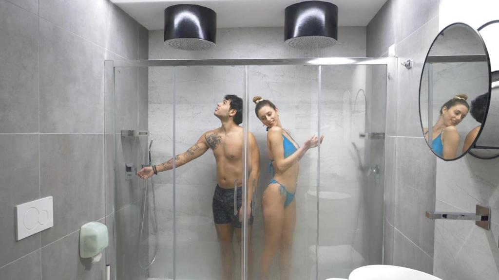 Ein Mann und eine Frau in einer Dusche im Bad. in der Unterkunft Villa Rocca - Rooms&SPA in Pizzo