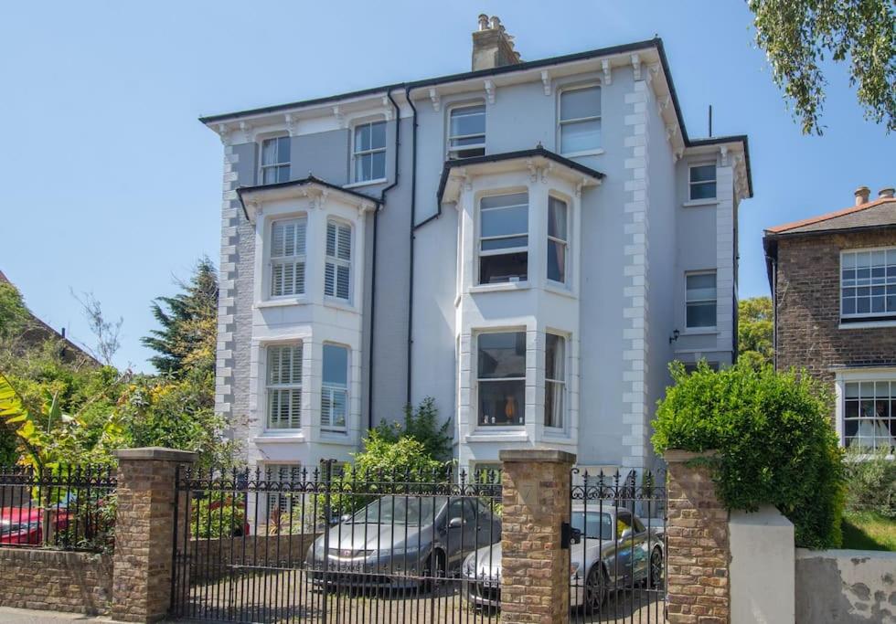 une maison blanche avec une voiture garée devant elle dans l'établissement Stunning large Victorian Maisonette with sea view, à Kent
