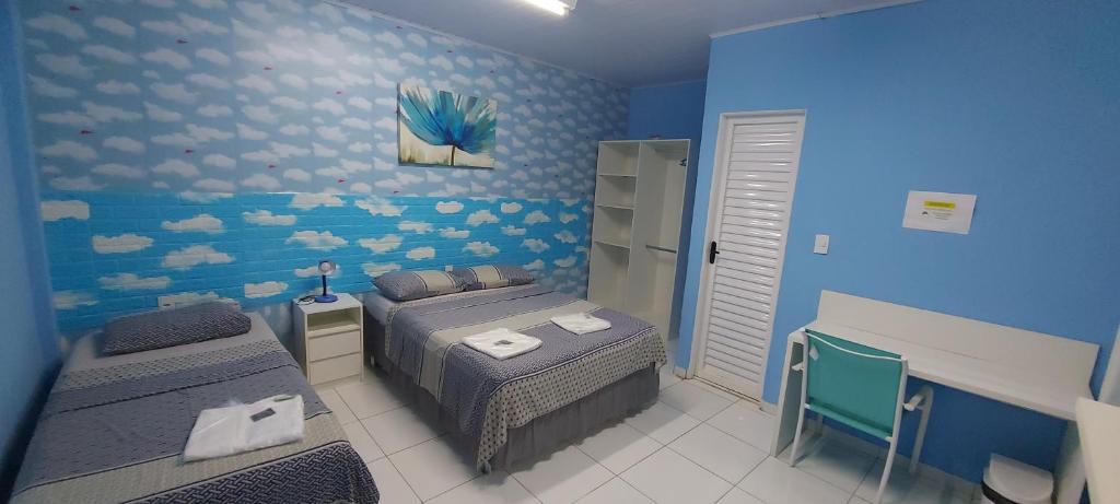 ein Schlafzimmer mit 2 Betten und einer blauen Wand in der Unterkunft Hotel Colors Manaus in Manaus