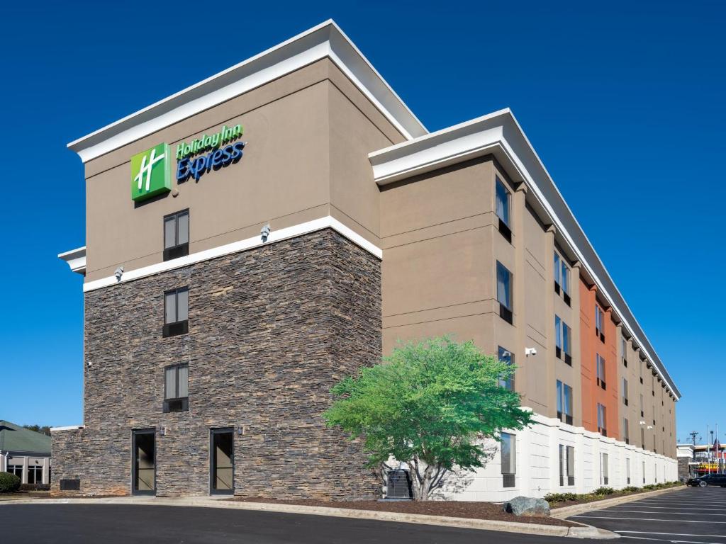 a hotel building with a hilton garden inn sign on it at Holiday Inn Express & Suites Greensboro - I-40 atWendover by IHG in Greensboro