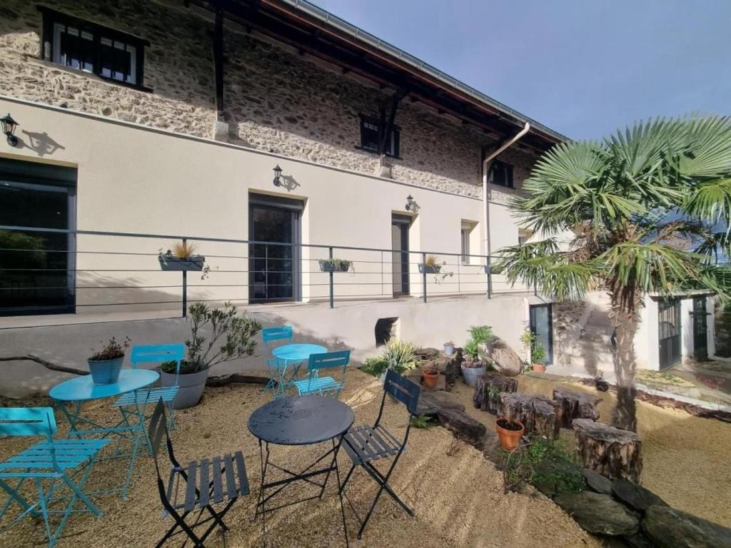 a patio with blue chairs and tables in front of a building at La voute du pilat in Saint-Chamond