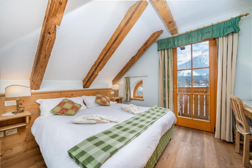 een slaapkamer met een bed en een raam bij Casa il Tiglio in Tarvisio