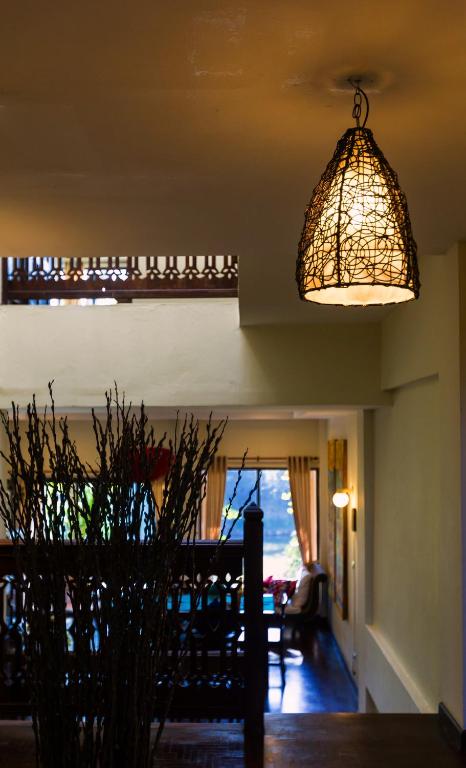 A warmly lit interior passage leads toward a seating area and bright window.